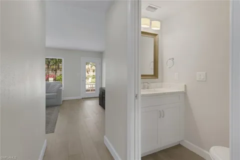 a view of a hallway with wooden floor and a cabinet