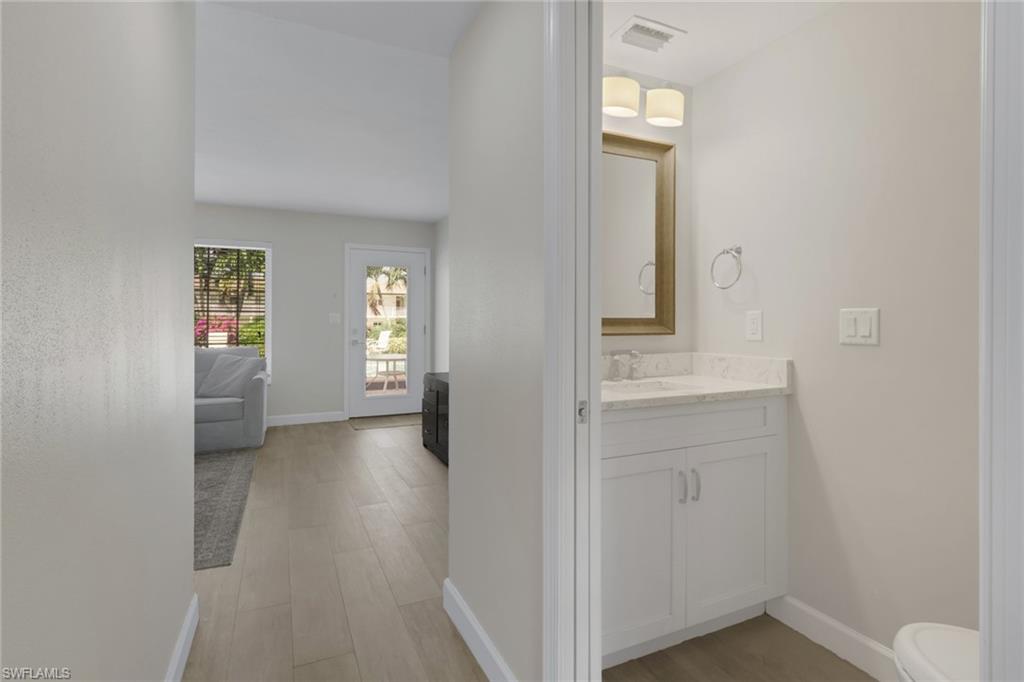 230 3rd Avenue South, Unit 4 Naples, FL 34102 - Photo 7 of 22 a view of a hallway with wooden floor and a cabinet