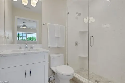 a bathroom with a toilet a sink a mirror and vanity