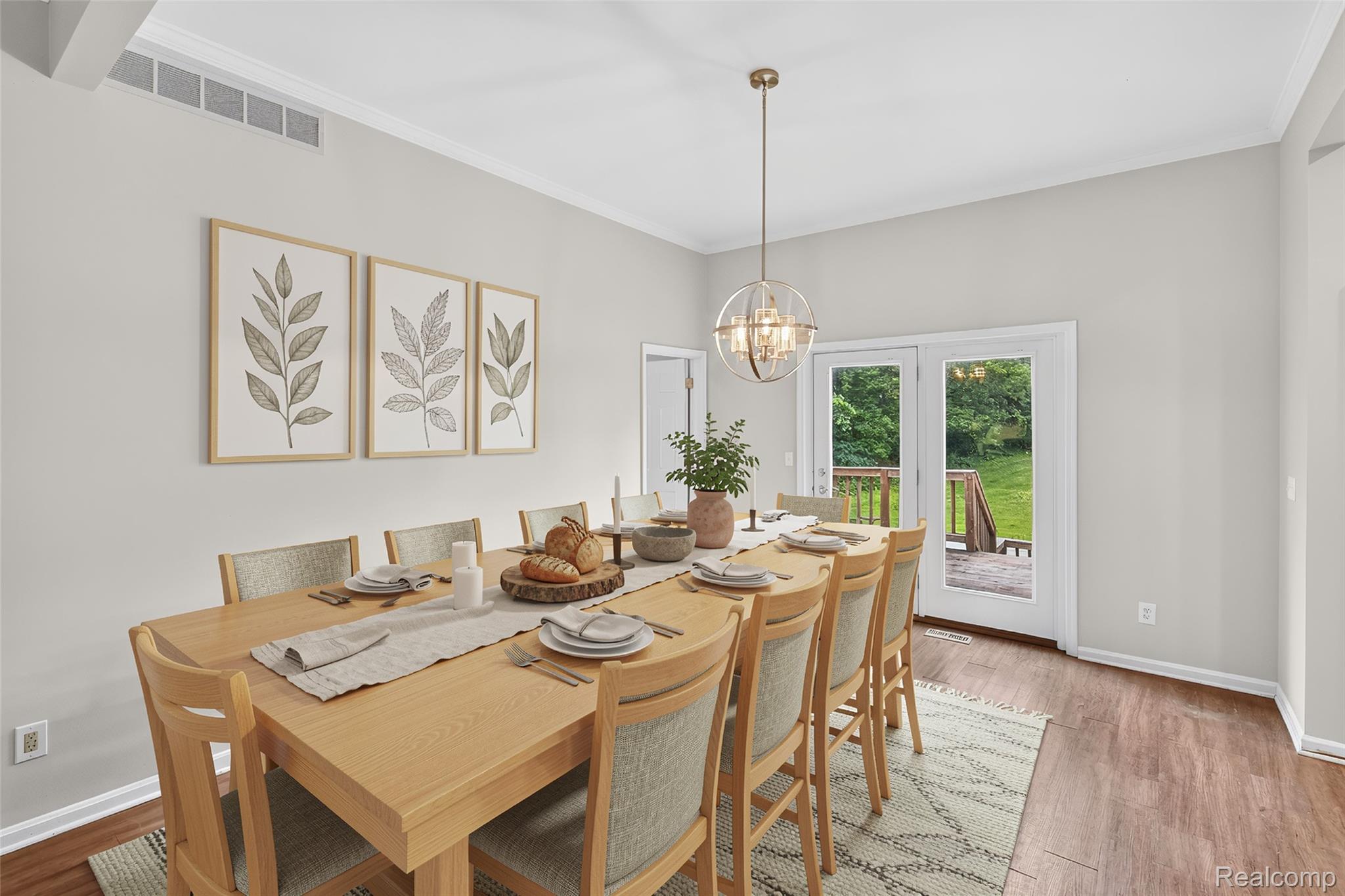 8114 Chilson Road Pinckney, MI 48169 - Photo 11 of 32 Spacious dining area featuring wood-finish flooring, white crown molding, and a contemporary spherical chandelier