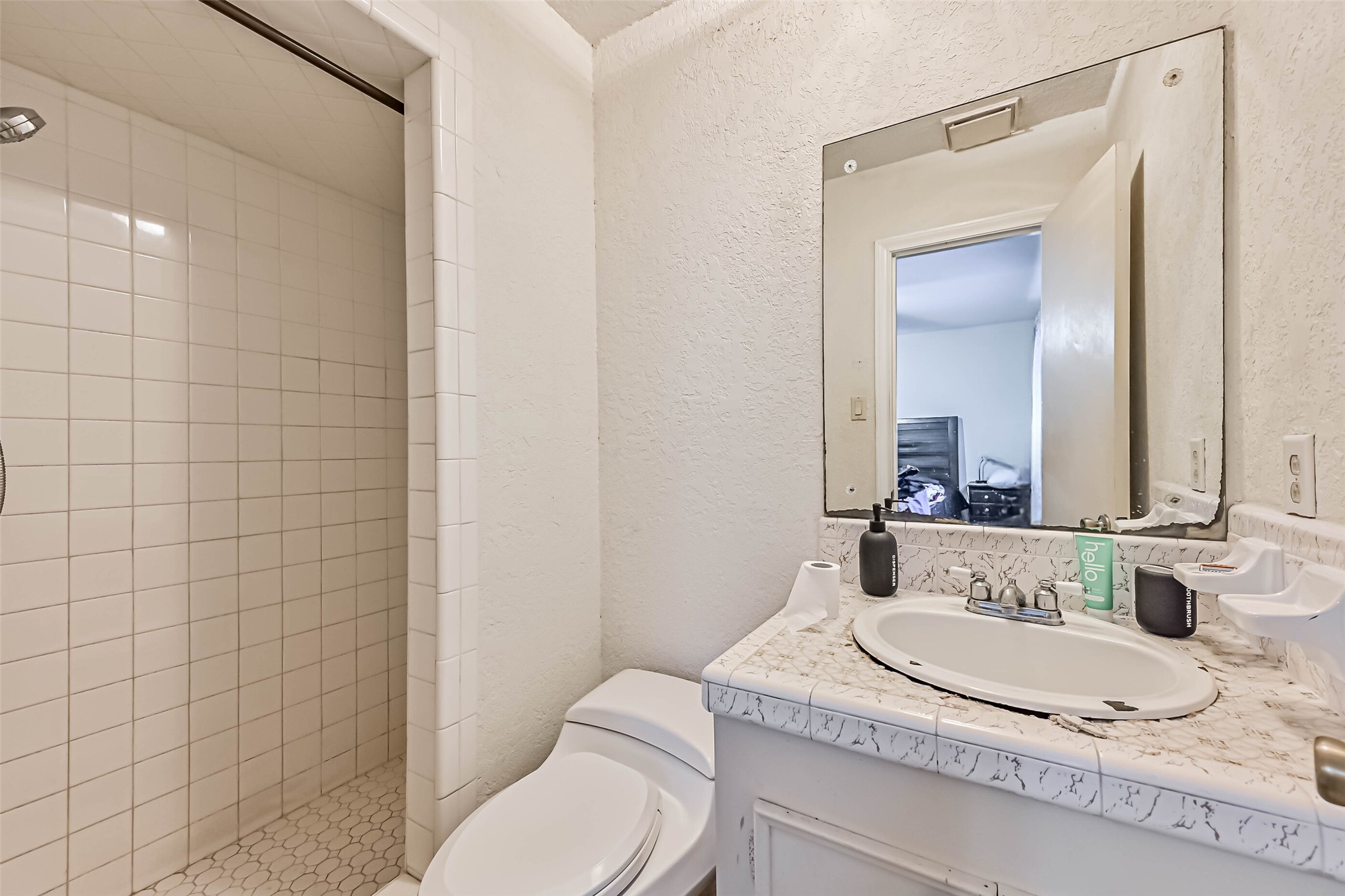 103 Deaton Street Freeport, TX 77541 - Photo 20 of 25 a bathroom with a granite countertop sink a toilet and a mirror
