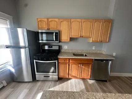 a kitchen with granite countertop a refrigerator stove and microwave