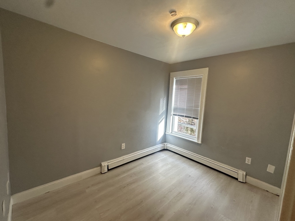 118 Gladstone Street, Unit B Boston, MA 02128 - Photo 12 of 16 an empty room with a empty space and window