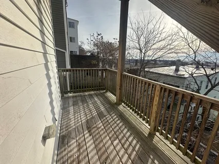 a view of balcony with wooden floor and fence