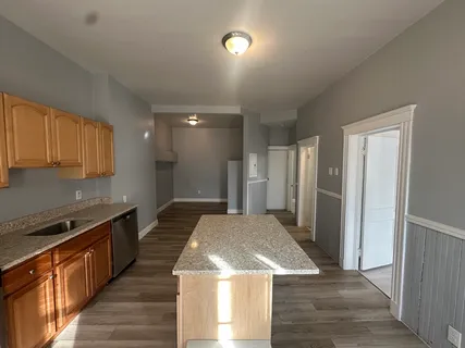 a kitchen with stainless steel appliances granite countertop a sink a stove and a refrigerator