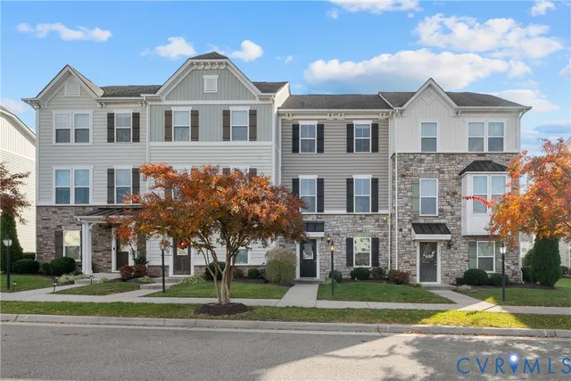 a front view of residential houses with yard and green space