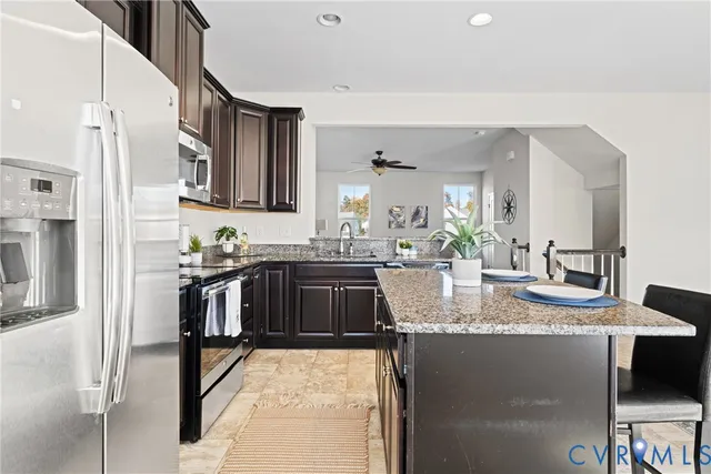 a kitchen with stainless steel appliances granite countertop a sink a stove and a refrigerator