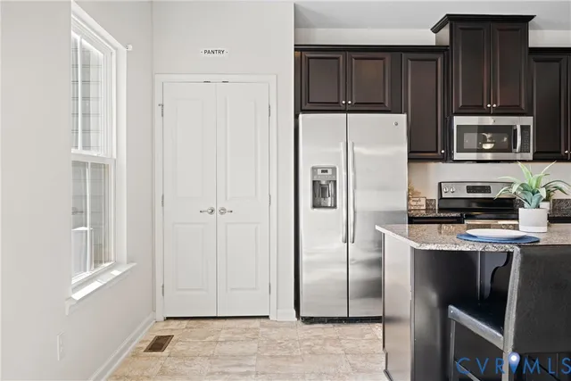 a kitchen with stainless steel appliances granite countertop a refrigerator stove and microwave