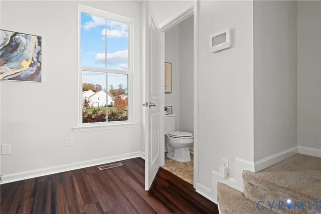 a view of room with wooden floor and bathroom