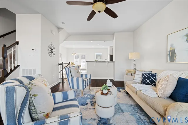 a living room with furniture and a dining table with wooden floor