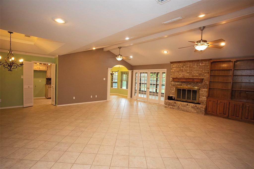 1305 Cliff Drive Graham, TX 76450 - Photo 14 of 37 a view of a livingroom with a fireplace a chandelier a ceiling fan and windows