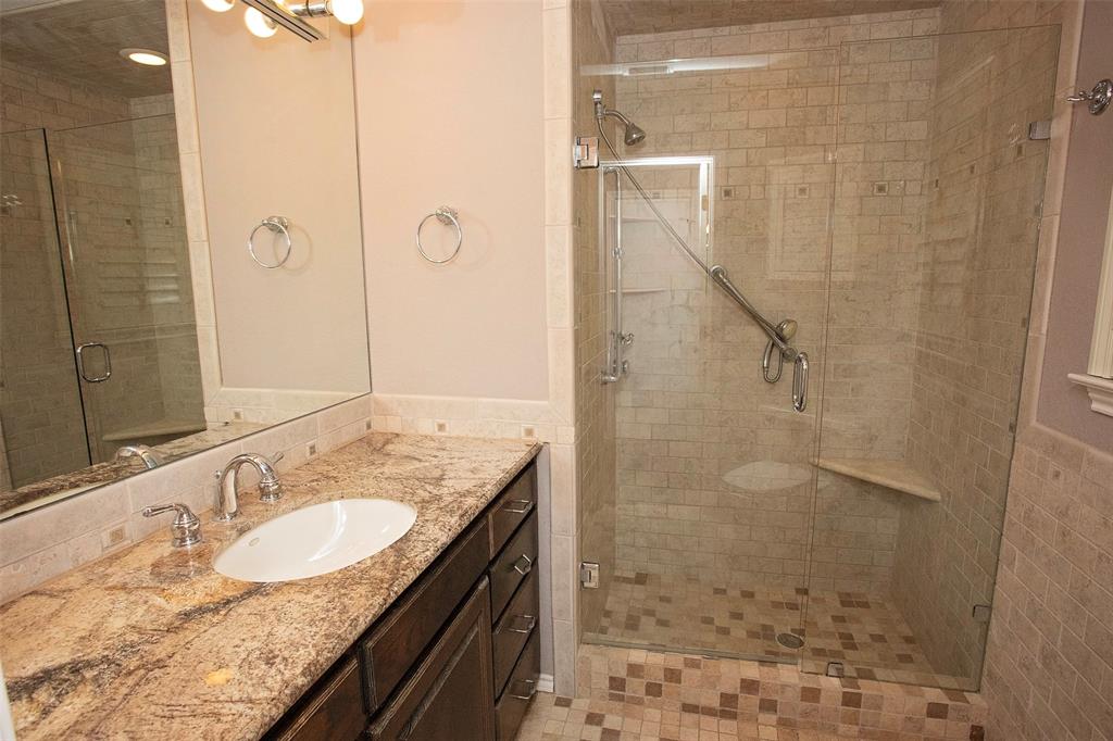 1305 Cliff Drive Graham, TX 76450 - Photo 23 of 32 a bathroom with a granite countertop shower a sink and a mirror