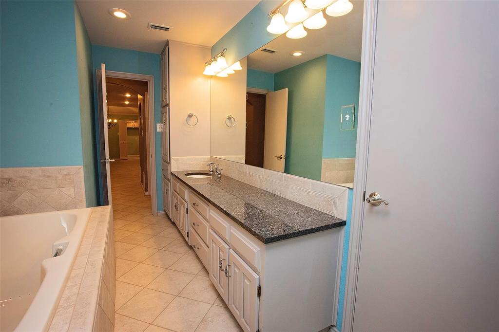 1305 Cliff Drive Graham, TX 76450 - Photo 27 of 32 a bathroom with a granite countertop sink and a mirror