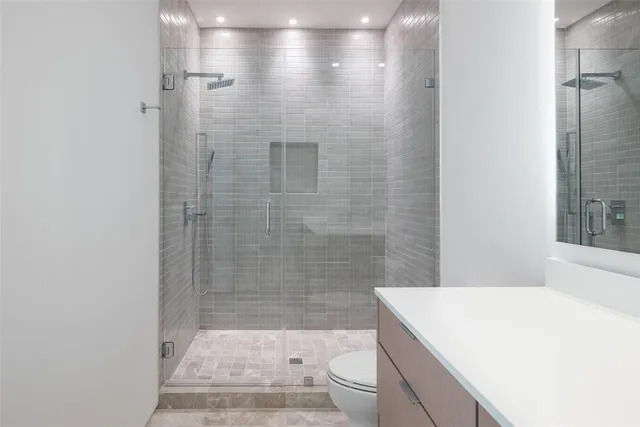 a bathroom with a sink a toilet and shower