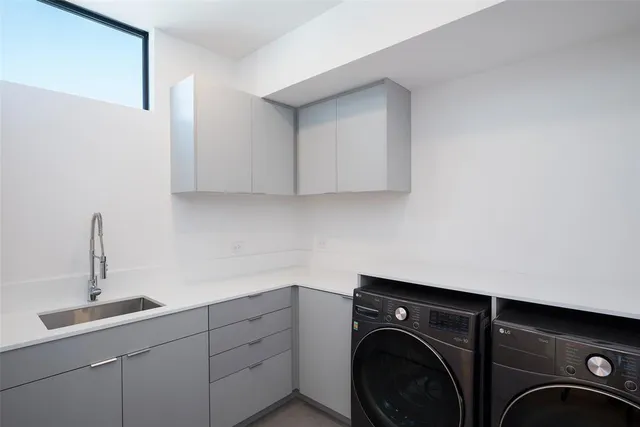 a utility room with sink dryer and washer