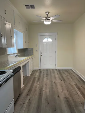 a kitchen with a sink cabinets and wooden floor