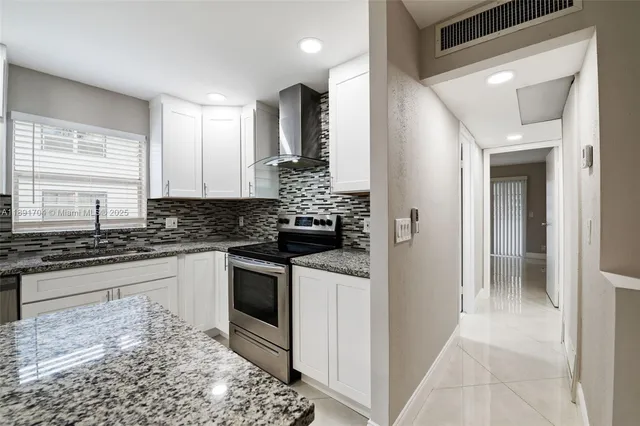 a kitchen with stainless steel appliances granite countertop a refrigerator sink and stove