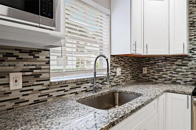 a view of a kitchen with a sink stainless steel appliances and cabinets