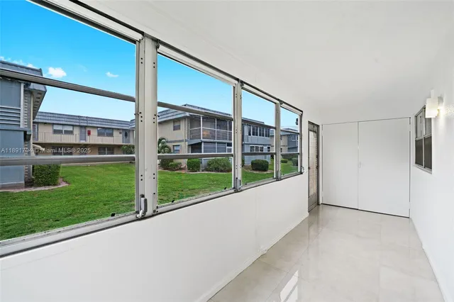 a dining room with furniture and a floor to ceiling window