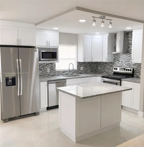 a kitchen with a refrigerator sink and cabinets