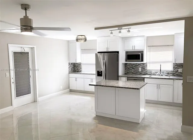 a kitchen with stainless steel appliances granite countertop a refrigerator sink and cabinets