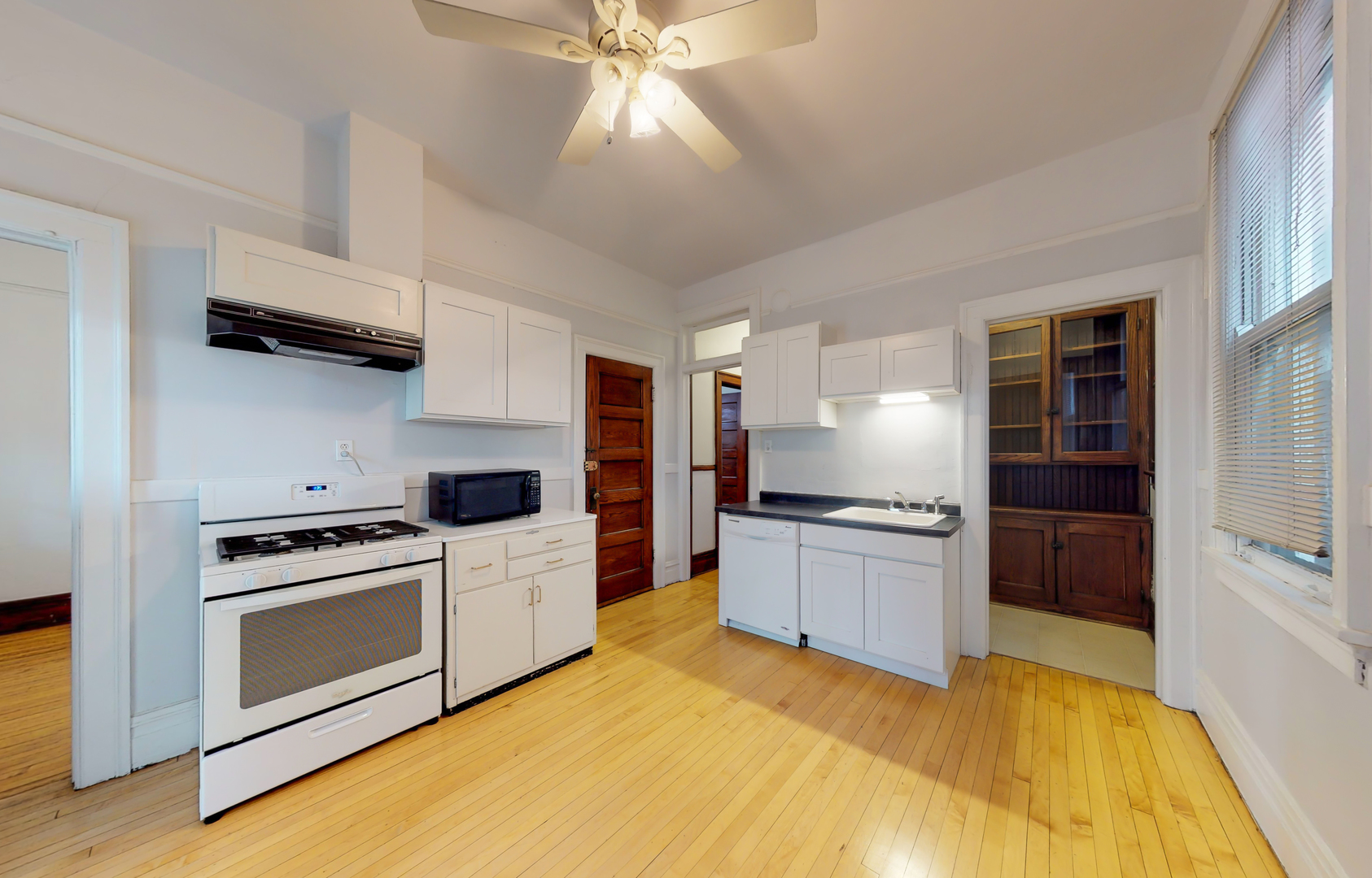 1127 West George Street Chicago, IL 60657 - Photo 14 of 16 a kitchen with a stove a sink and a refrigerator