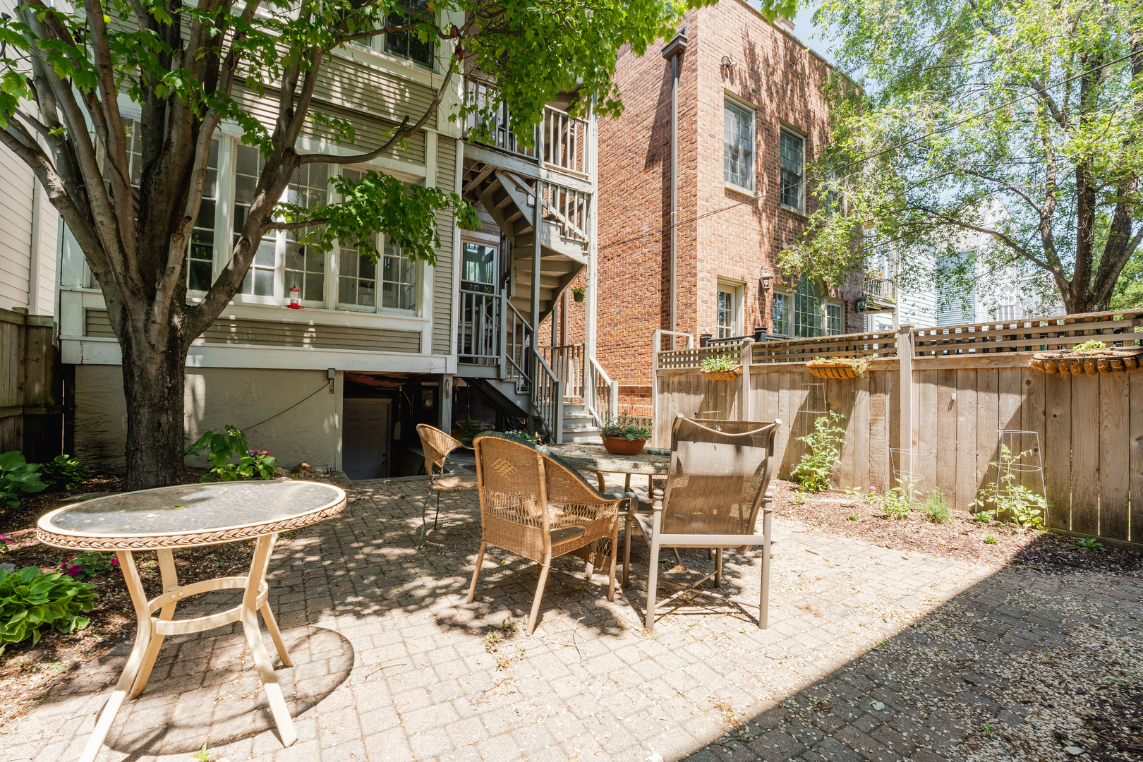 1127 West George Street Chicago, IL 60657 - Photo 16 of 16 a view of a patio with table and chairs with wooden fence and plants