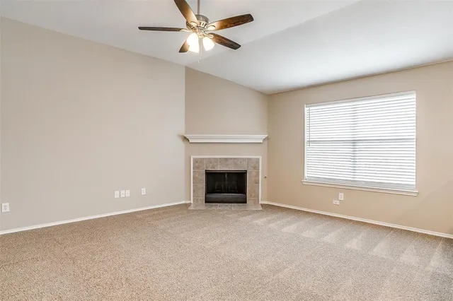 a view of empty room with fan and windows