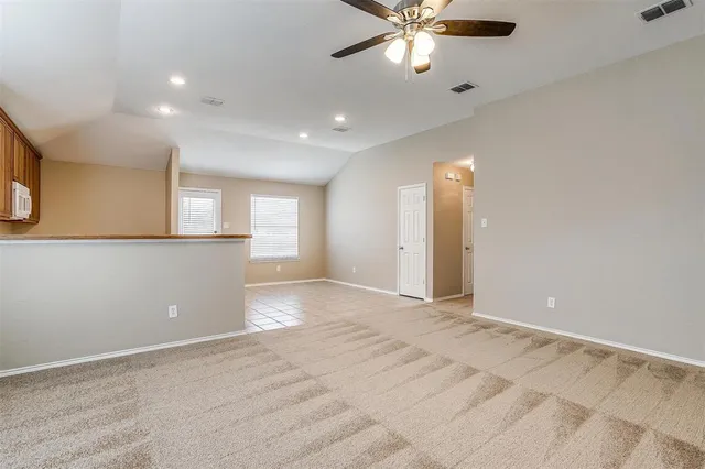 an empty room with a window and a ceiling fan