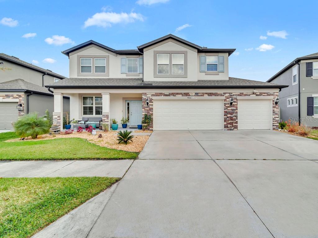 a front view of a house with a yard and potted plants