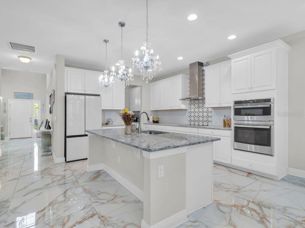 7406 Sweeter Tide Trail Wesley Chapel, FL 33545 - Photo 13 of 74 a kitchen with stainless steel appliances granite countertop a sink and cabinets