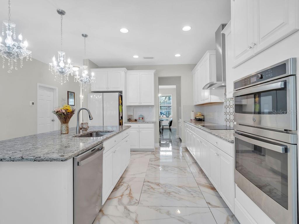 7406 Sweeter Tide Trail Wesley Chapel, FL 33545 - Photo 14 of 74 a large kitchen with granite countertop a large counter top a sink stainless steel appliances and cabinets