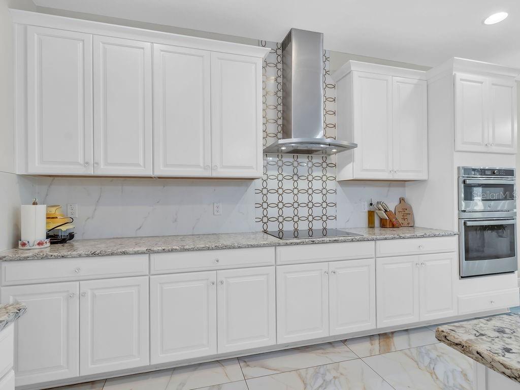 7406 Sweeter Tide Trail Wesley Chapel, FL 33545 - Photo 16 of 74 a kitchen with white cabinets and white appliances
