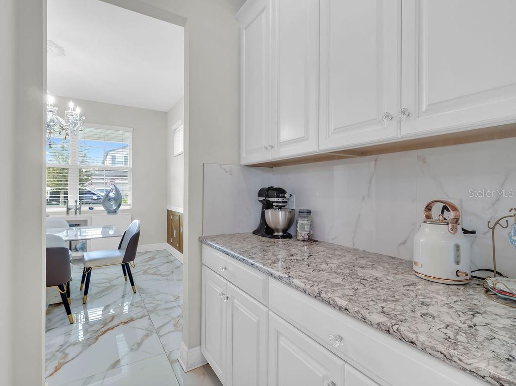 7406 Sweeter Tide Trail Wesley Chapel, FL 33545 - Photo 17 of 74 a kitchen with granite countertop cabinets and chair