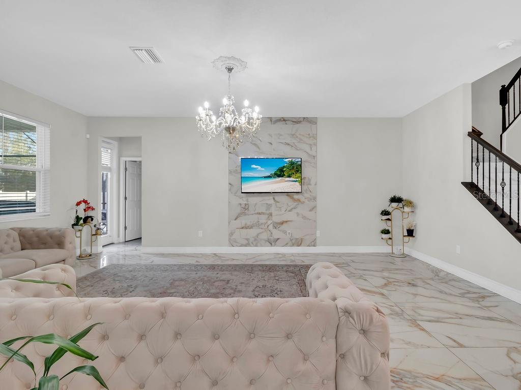 7406 Sweeter Tide Trail Wesley Chapel, FL 33545 - Photo 23 of 74 a spacious bedroom with a bed and a chandelier