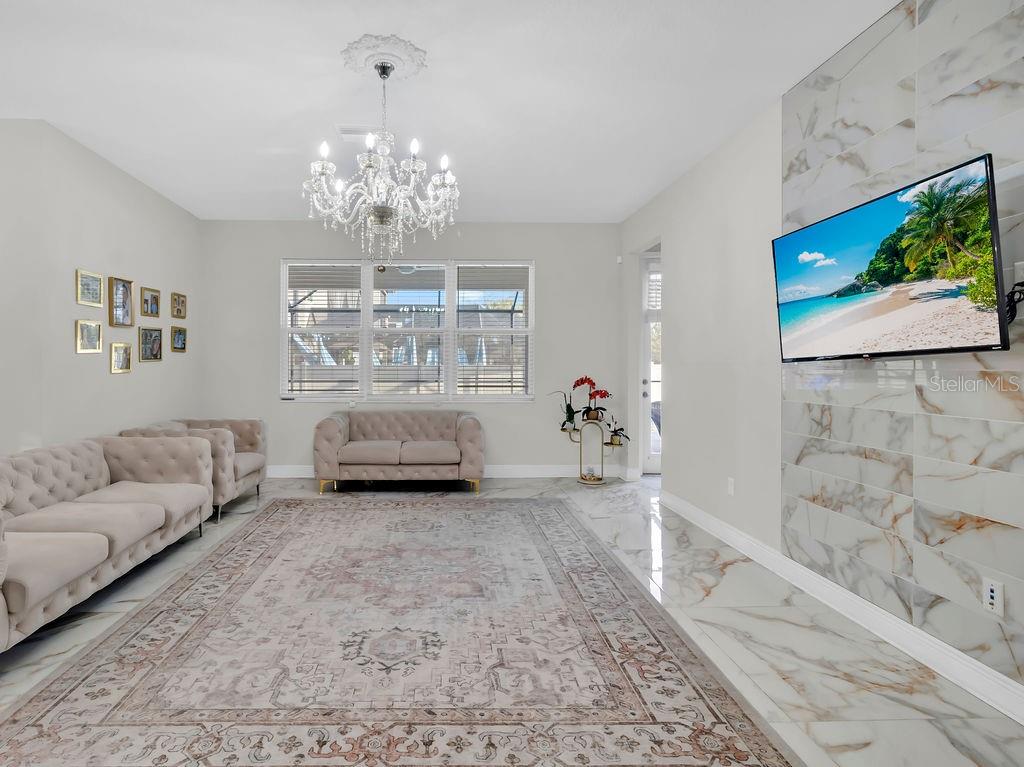 7406 Sweeter Tide Trail Wesley Chapel, FL 33545 - Photo 24 of 74 a living room with furniture and a chandelier