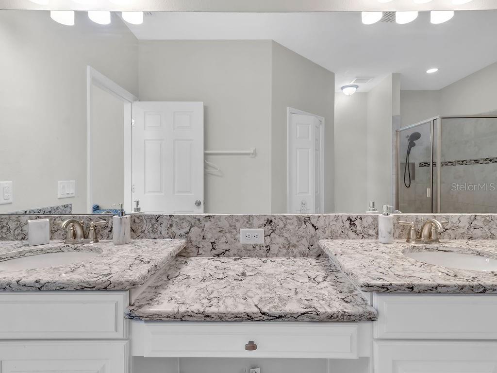 7406 Sweeter Tide Trail Wesley Chapel, FL 33545 - Photo 30 of 74 a bathroom with a granite countertop sink and a mirror
