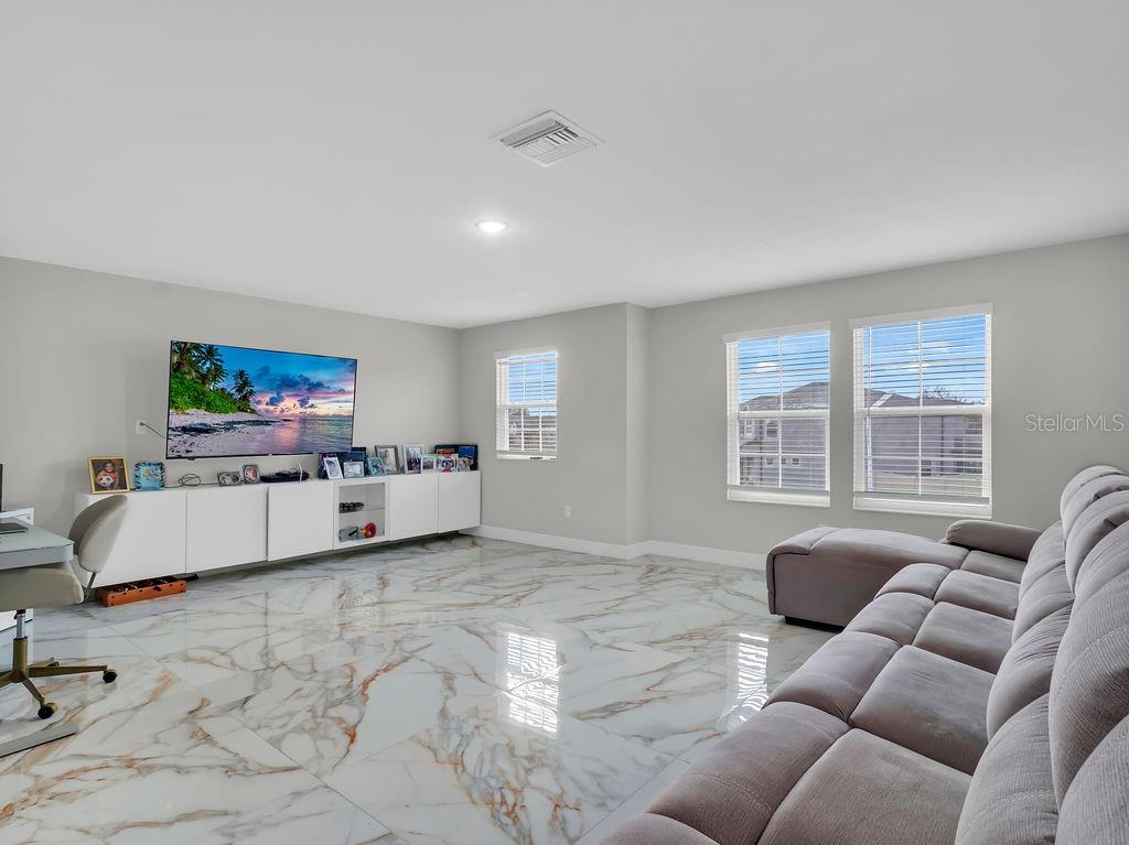 7406 Sweeter Tide Trail Wesley Chapel, FL 33545 - Photo 42 of 74 a living room with furniture and a flat screen tv