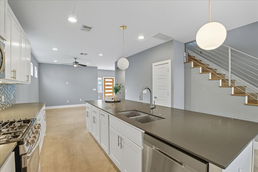 6902 Bennett Avenue, Unit B Austin, TX 78752 - Photo 10 of 27 Kitchen with white cabinetry, decorative backsplash, appliances with stainless steel finishes, hanging light fixtures, and recessed lighting