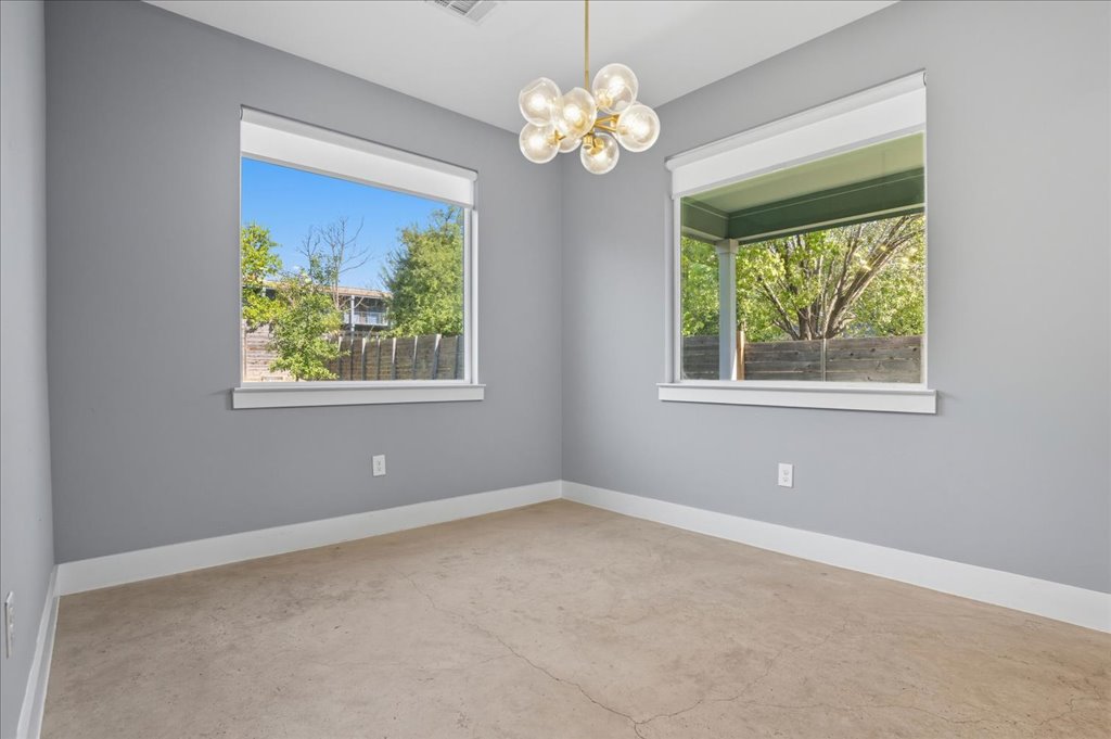 6902 Bennett Avenue, Unit B Austin, TX 78752 - Photo 12 of 27 Unfurnished room with a chandelier and unfinished concrete floors