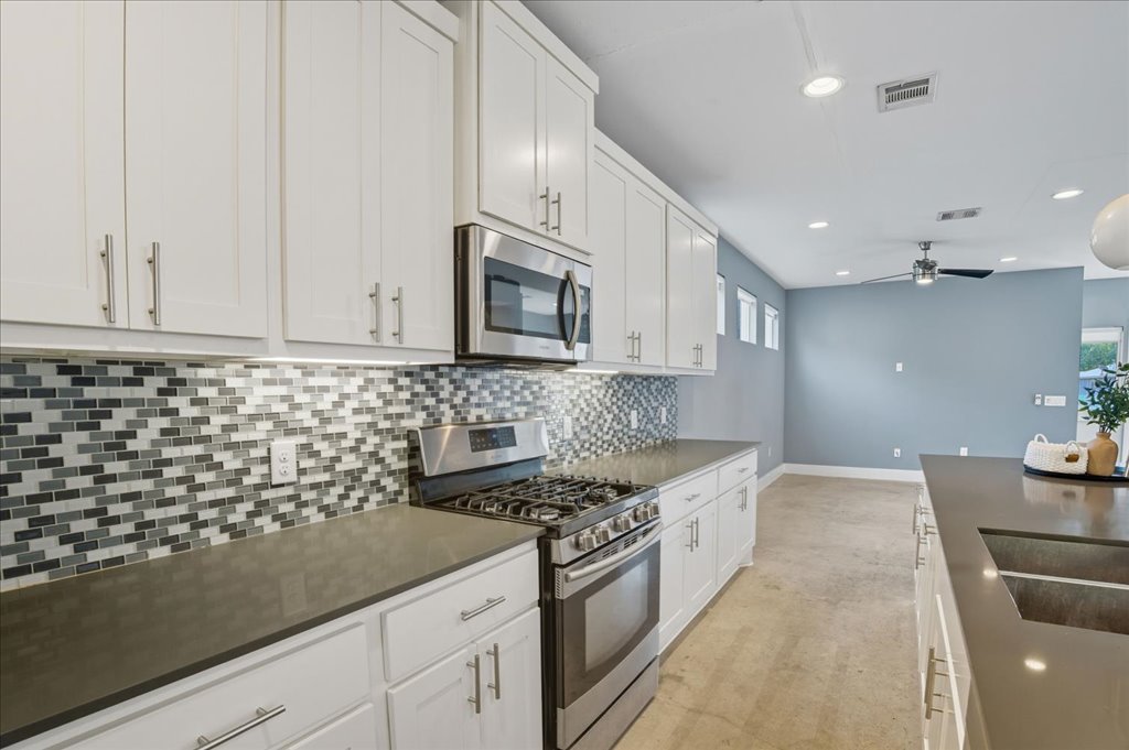 6902 Bennett Avenue, Unit B Austin, TX 78752 - Photo 2 of 27 Kitchen featuring appliances with stainless steel finishes, white cabinets, tasteful backsplash, recessed lighting, and a ceiling fan
