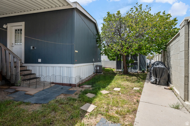 150 West 7500th South, Unit 13 Midvale, UT 84047 - Photo 31 of 32 Side yard with an established tree, concrete pathway, and block wall fencing