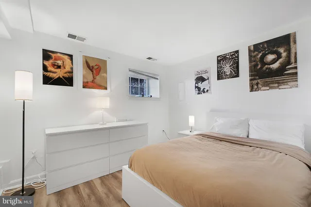 a bedroom with a bed and painting on the wall