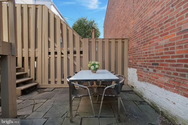 a view of a patio with table and chairs with wooden fence and plants