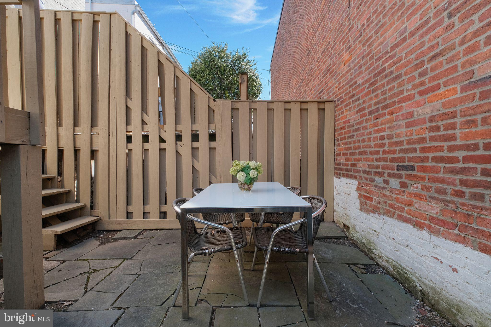 3256 Q Street Northwest Washington, DC 20007 - Photo 20 of 20 a view of a patio with table and chairs with wooden fence and plants