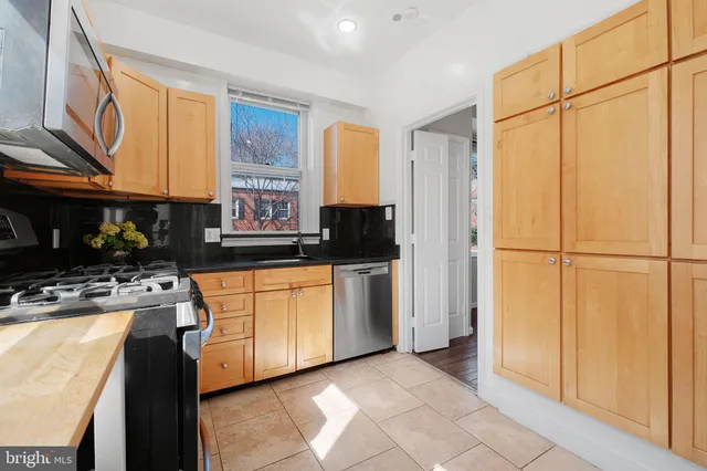 a kitchen with stainless steel appliances granite countertop a refrigerator and a stove top oven