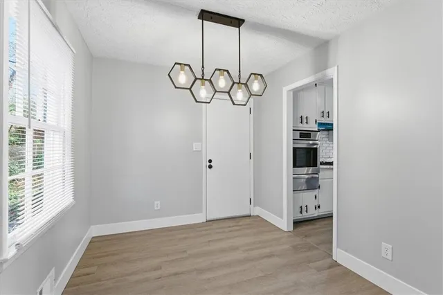 a view of empty room with wooden floor and window