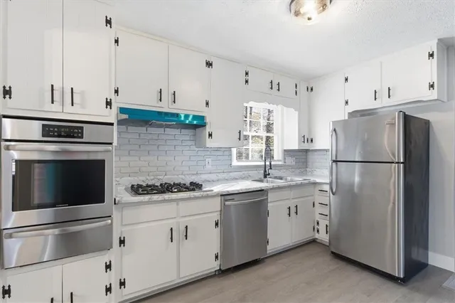 a kitchen with appliances a sink and lots of cabinets