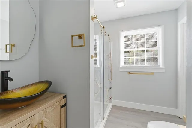a bathroom with a granite countertop sink and a window