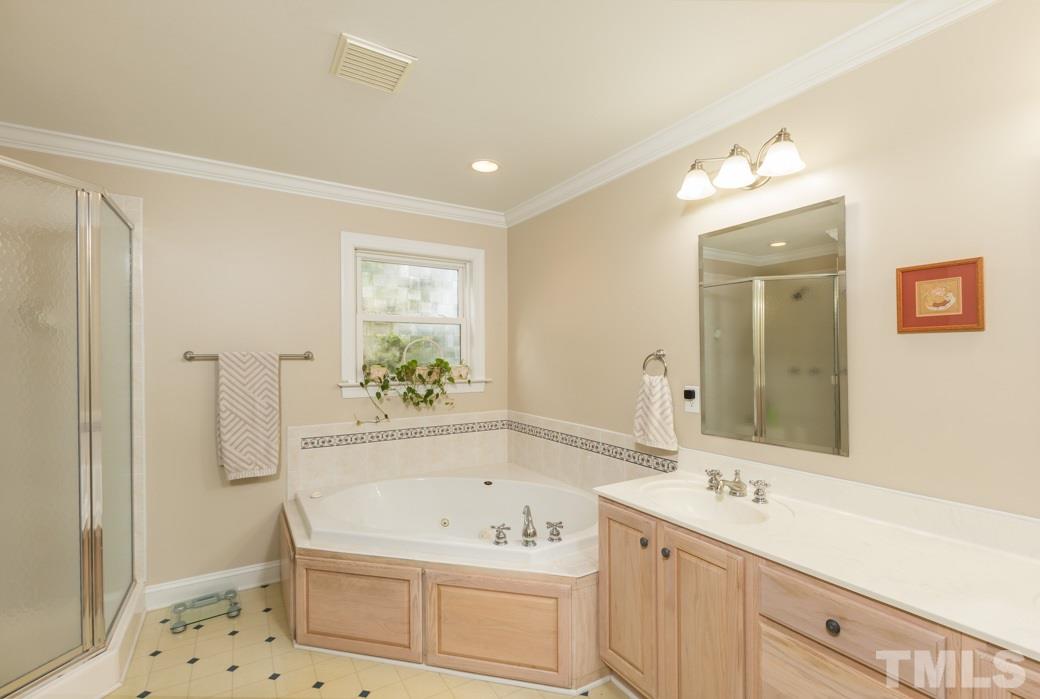 8632 Langtree Lane Raleigh, NC 27613 - Photo 11 of 25 a bathroom with a tub a sink and mirror